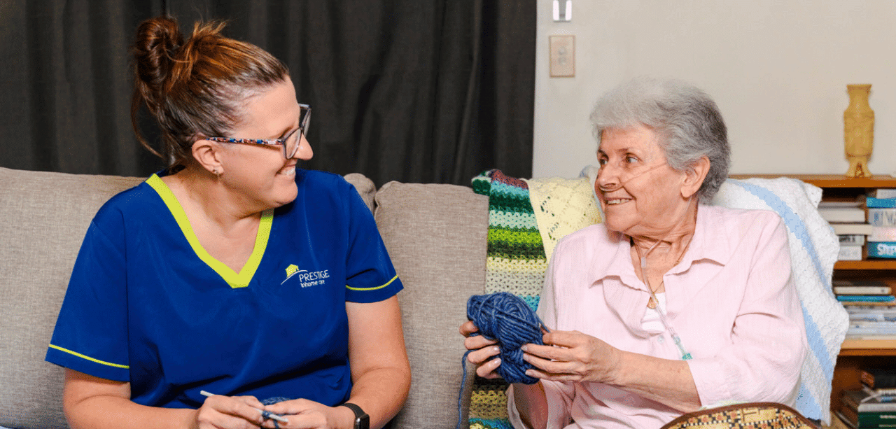 Prestige client Jenny with her carer knitting