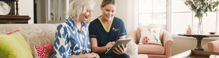 Prestige Client with carer in her home looking at tablet